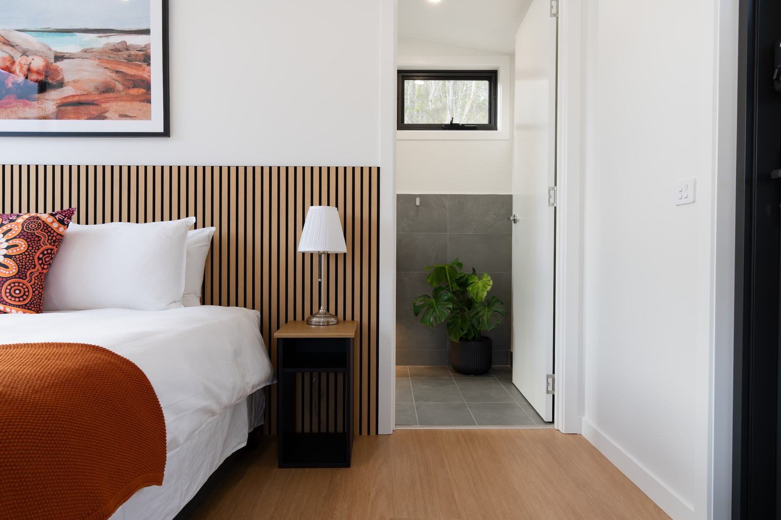 Inside the bedroom of ironbark showing the plush bed and door into bathroom