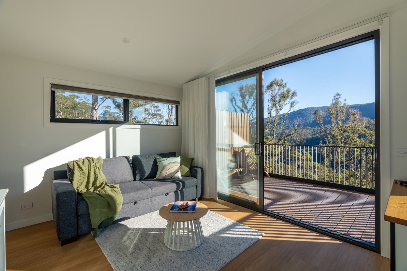 Mosswood cabin living room looking out to deck and forest views