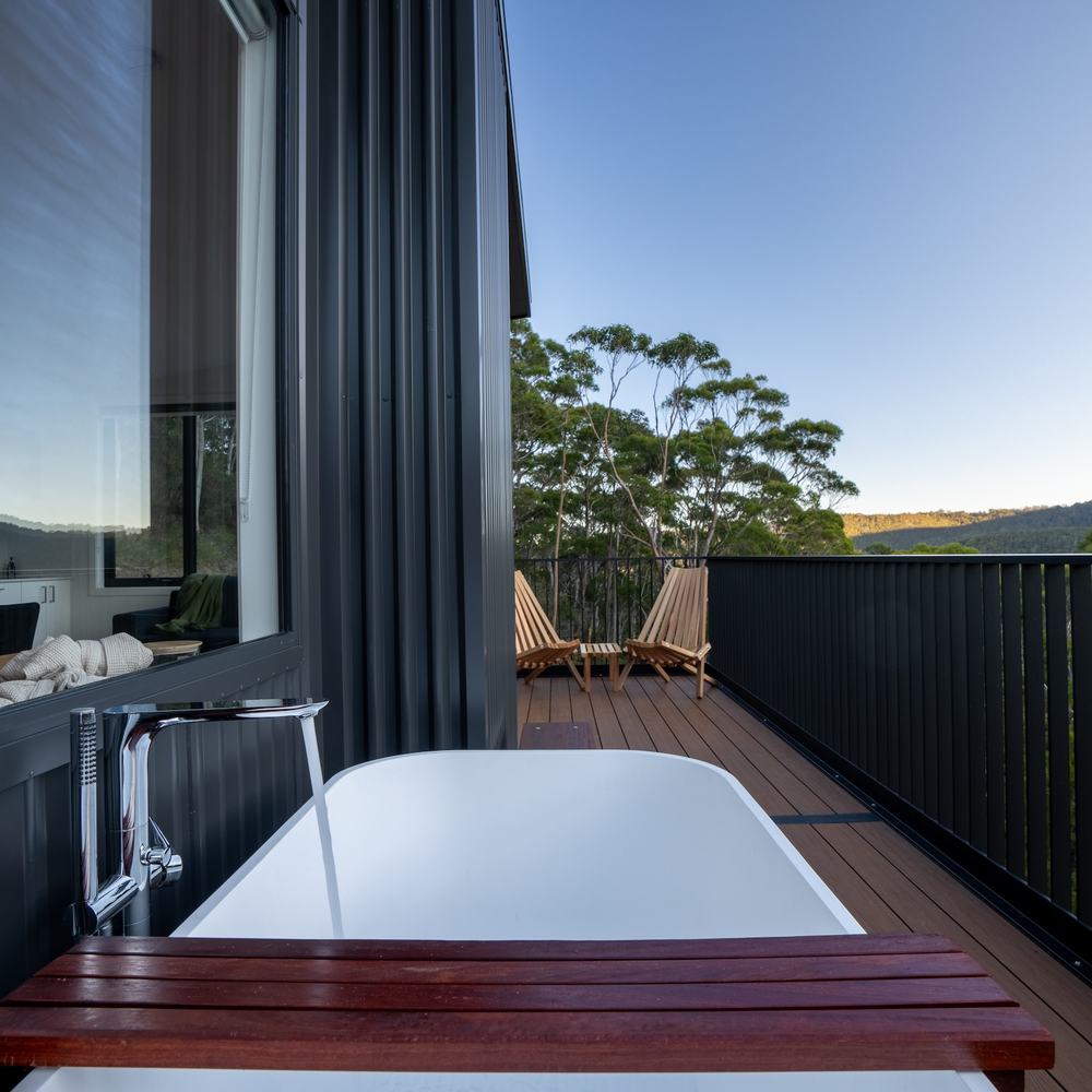 Outdoor bath on deck overlooking forest and mountain