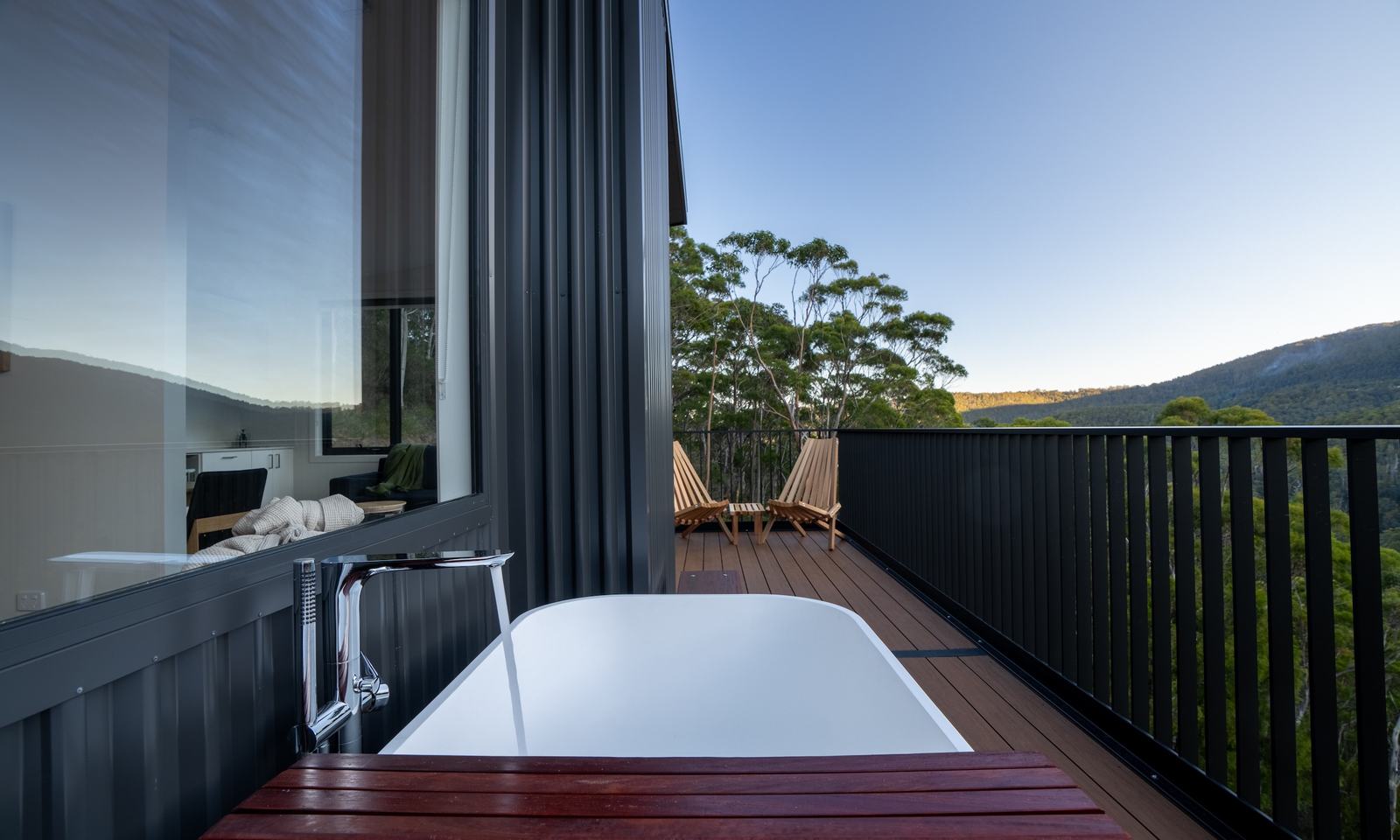 Outdoor bath on deck overlooking forest and mountain