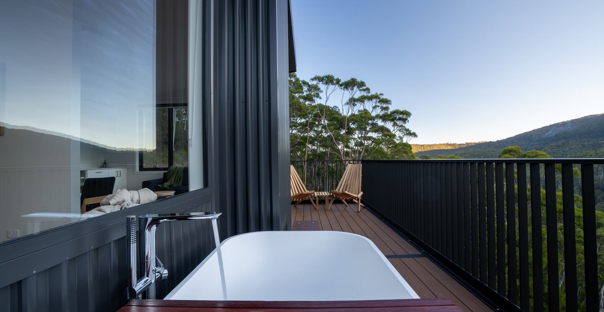 Outdoor bath on deck overlooking forest and mountain