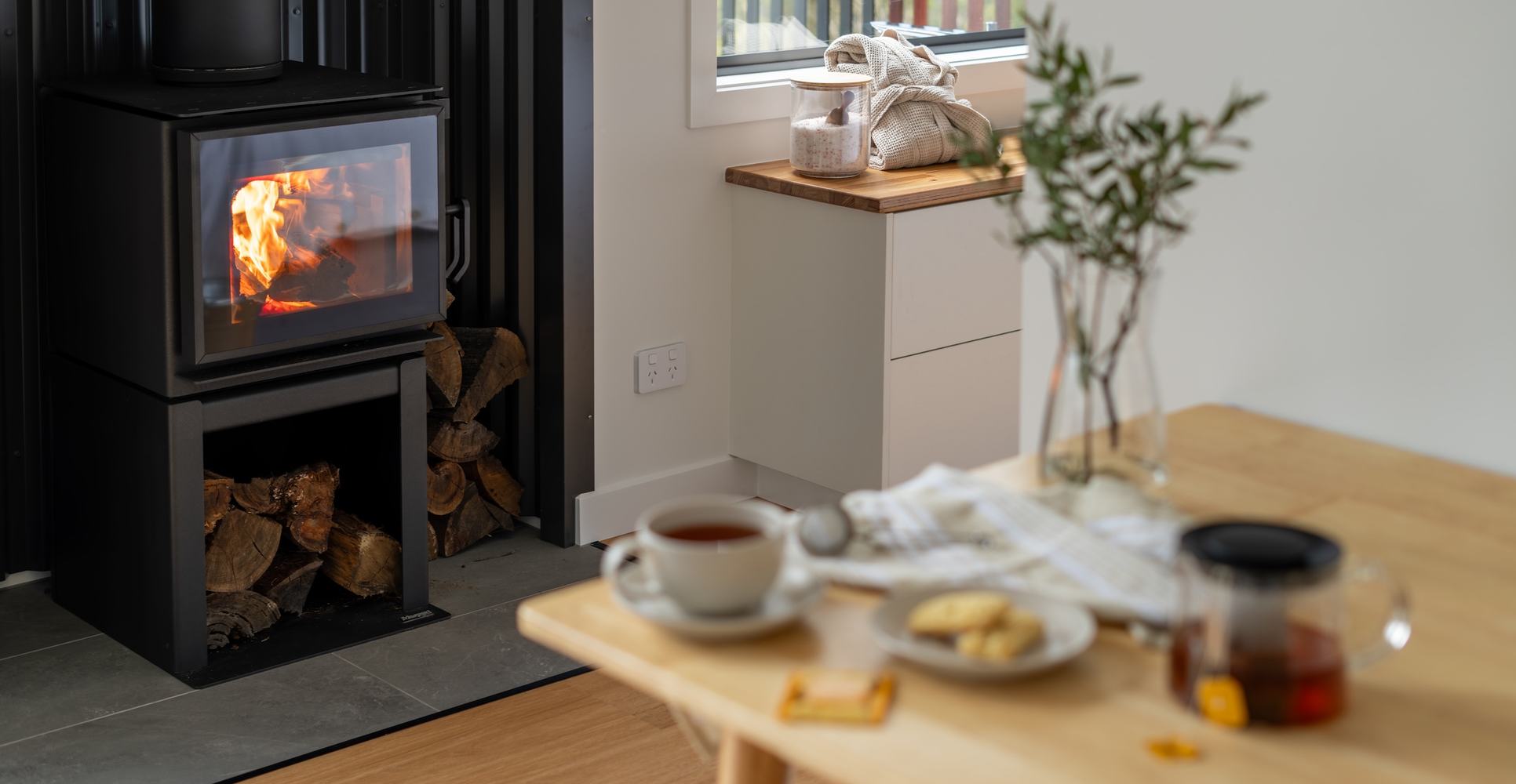 Warm fireplace with tea and biscuits waiting on the table nearby