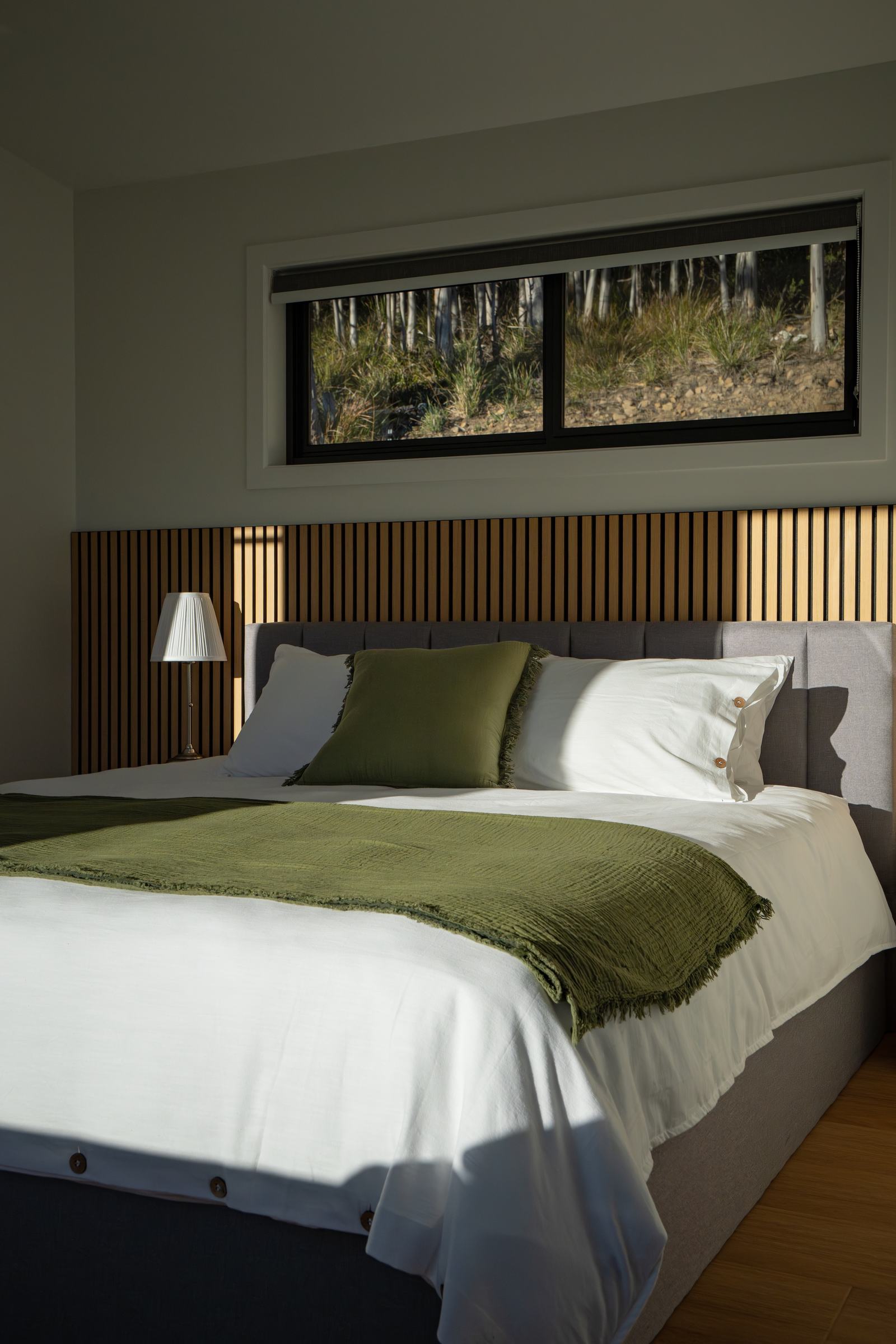 Bedroom of stillwater cabin with sunlight streaming through window