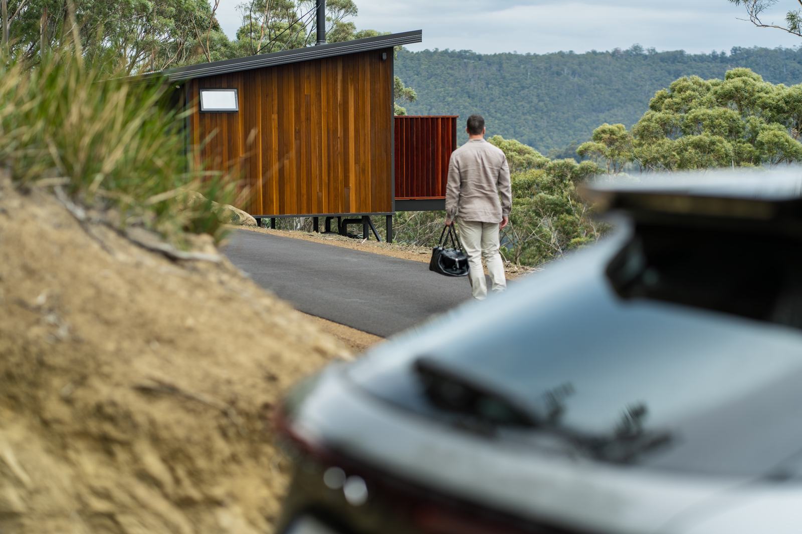 Person arriving to mountain side cabin walking from their car