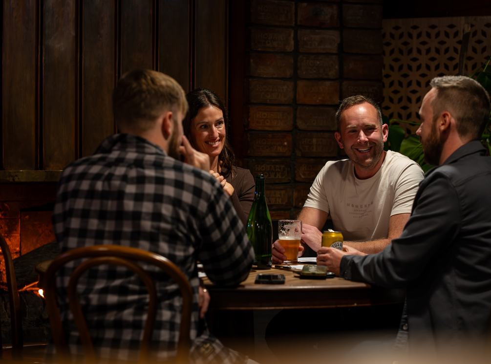 People sitting around table with drinks smiling